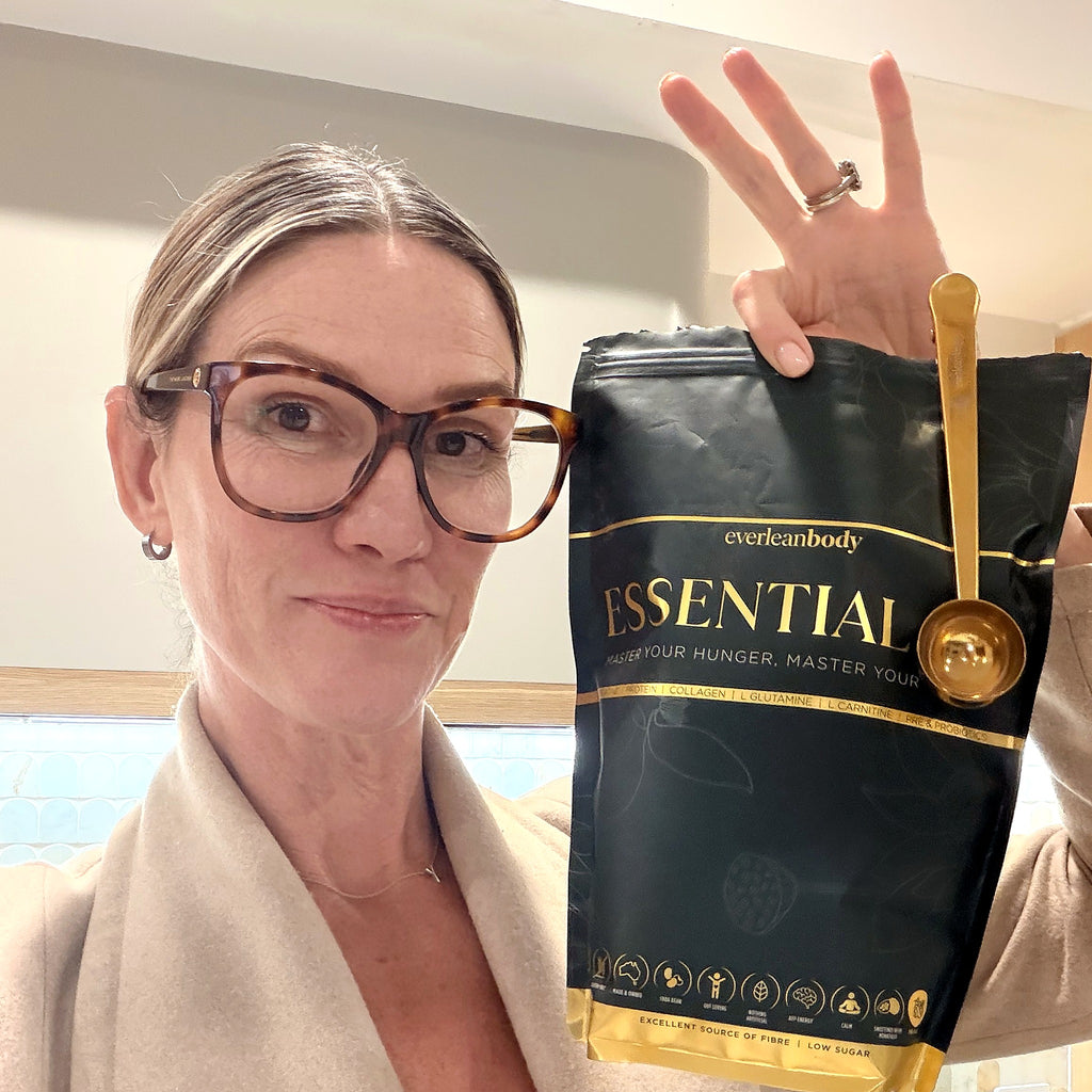 Kel holding an EssentialAF pouch with the gold scoop clipped to the top